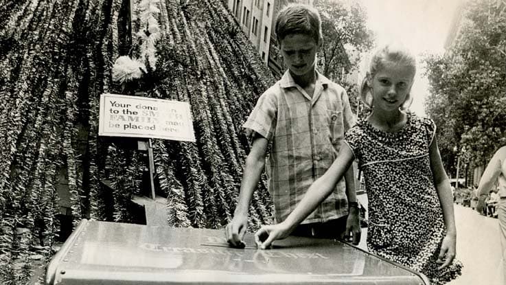 Children placing a donation in the Christmas Treasure Chest at Martin Place