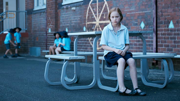Amy sitting alone in playground