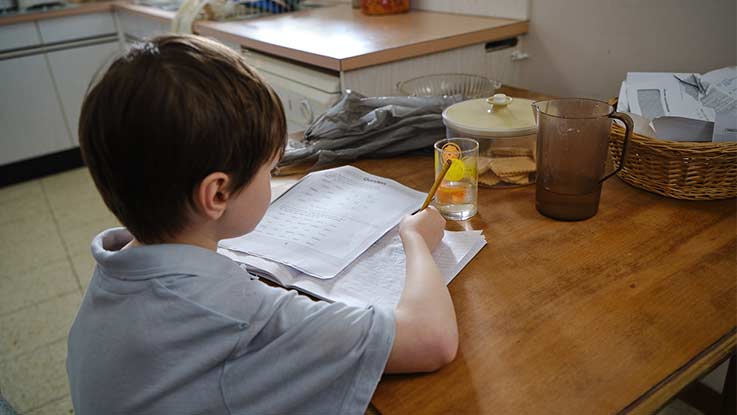 Billy doing homework at kitchen table