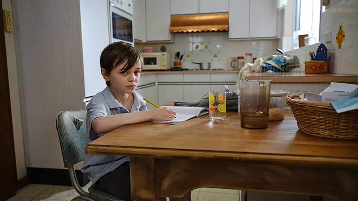 Billy doing school work at kitchen table