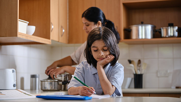 Girl doing homework in a kitchen.