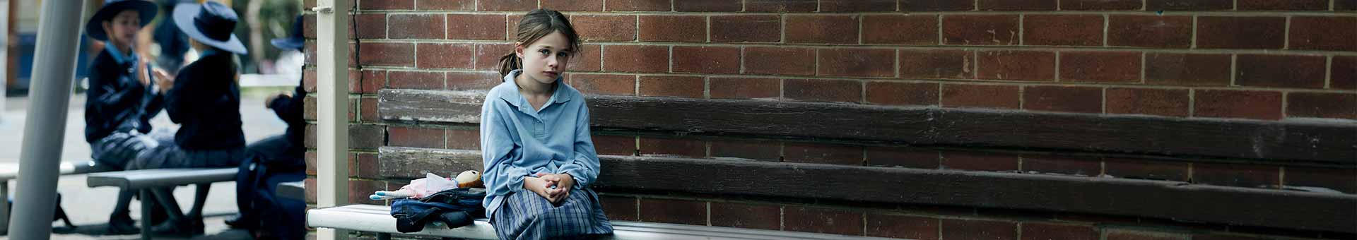 Sarah sitting on bench in the playground