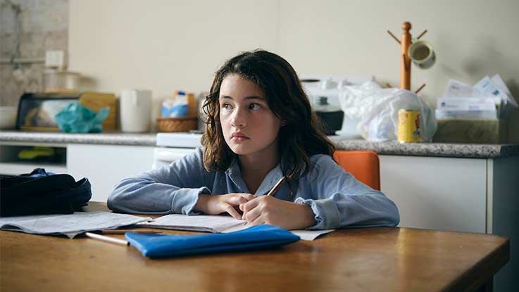 Lucy doing her homework in her kitchen