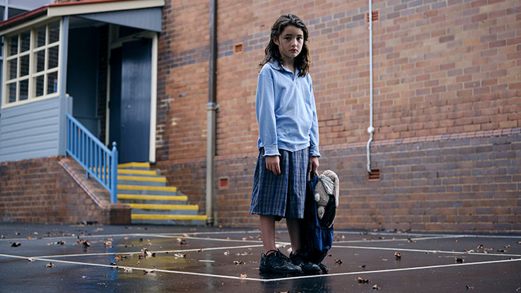Lucy standing in playground