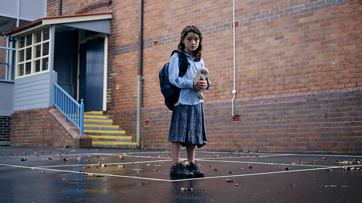 Lucy standing in playground