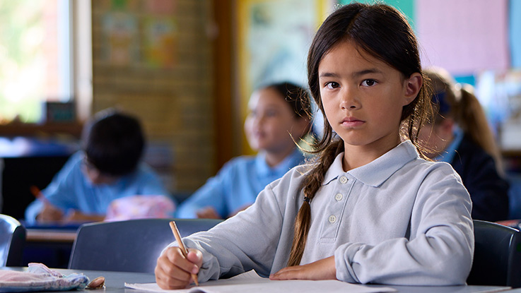 a school girl in a classroom looking sad
