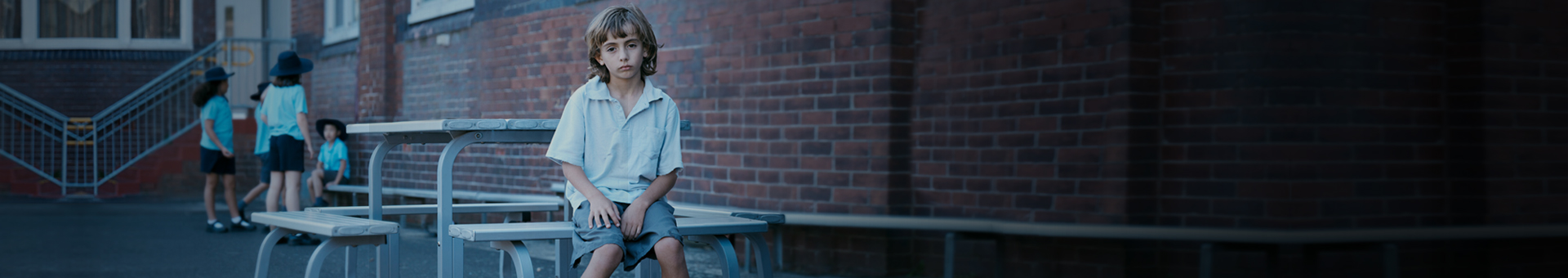 Zack sitting alone at playground table