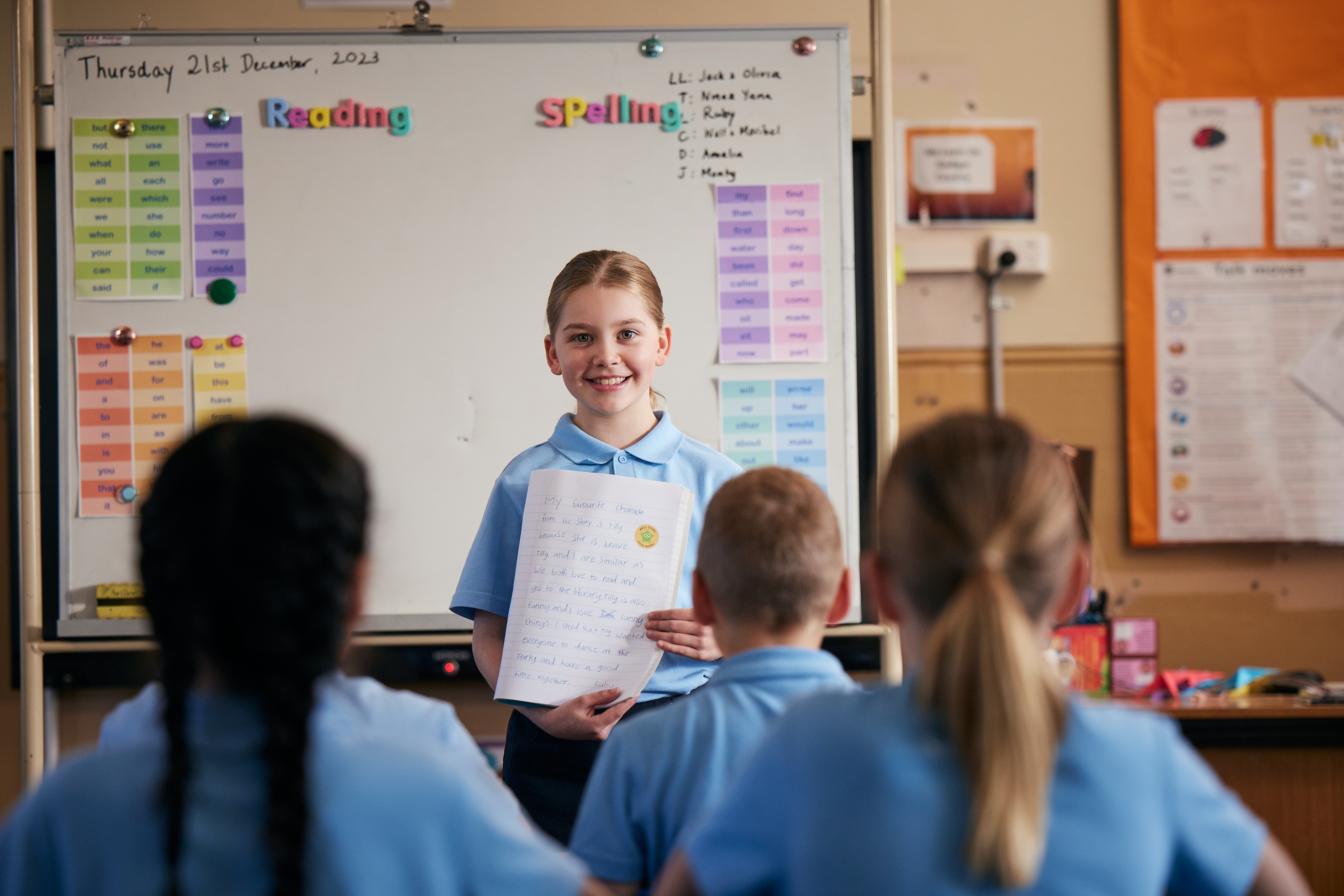 Student presenting work to classmates in a primary school classroom.