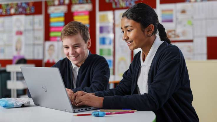Two primary students and laptop
