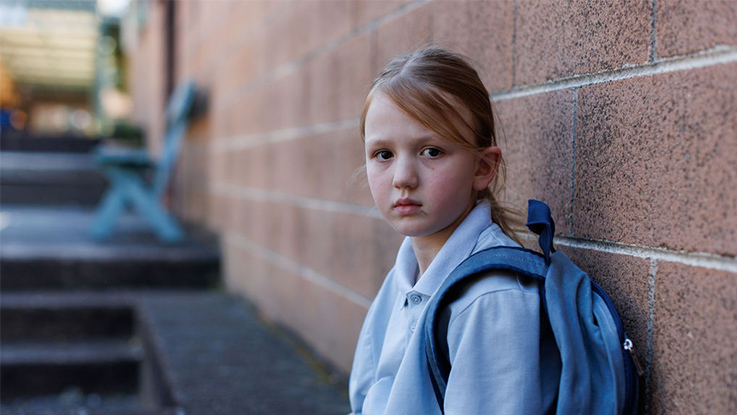 A girl walking down the school hall