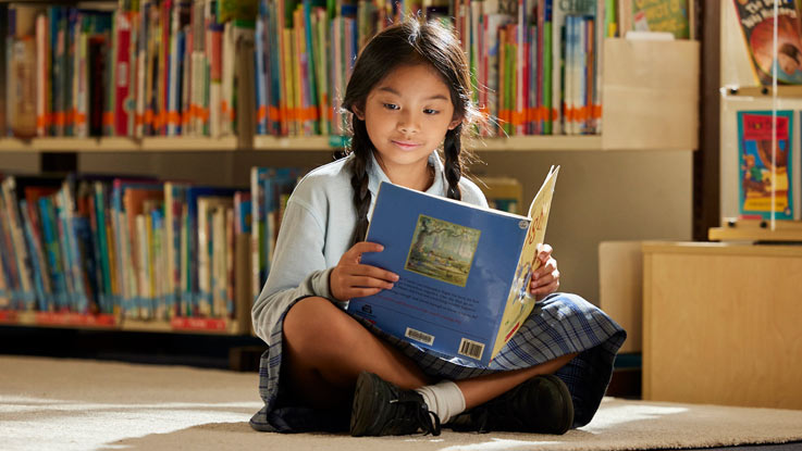 Girl sitting on floor in library