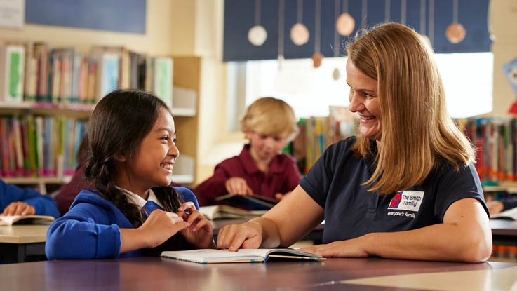 Girl sitting at desk with a teacher