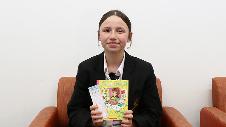 a school girl holding her book and bookmark