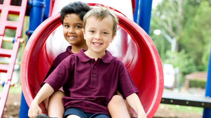 Two boys on a slippery slide
