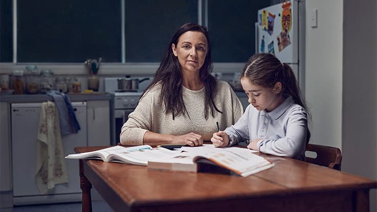 Girl and her mum, doing homework at kitchen table