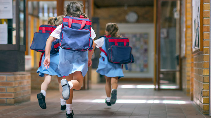 three-school-girls-running-in-school-coridor