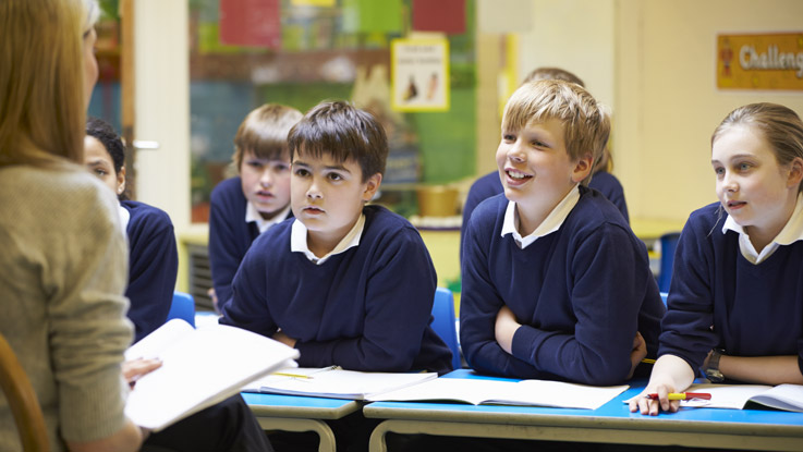 Students sitting at desk listening to teacher
