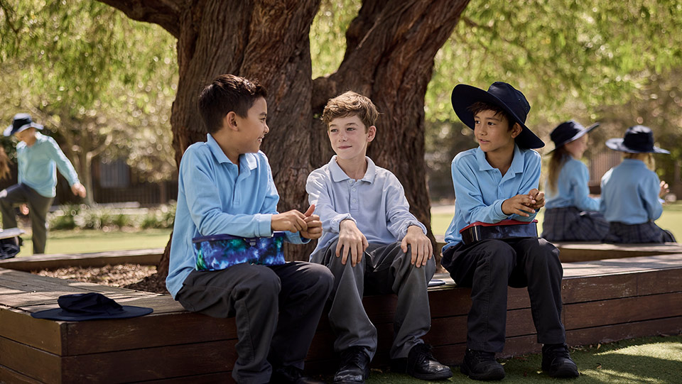 school children outside in the playground sitting together