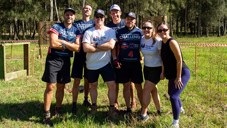 A group of people standing outside posing for a photo