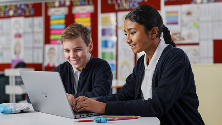 Students laughing in school hallway wearing school uniform