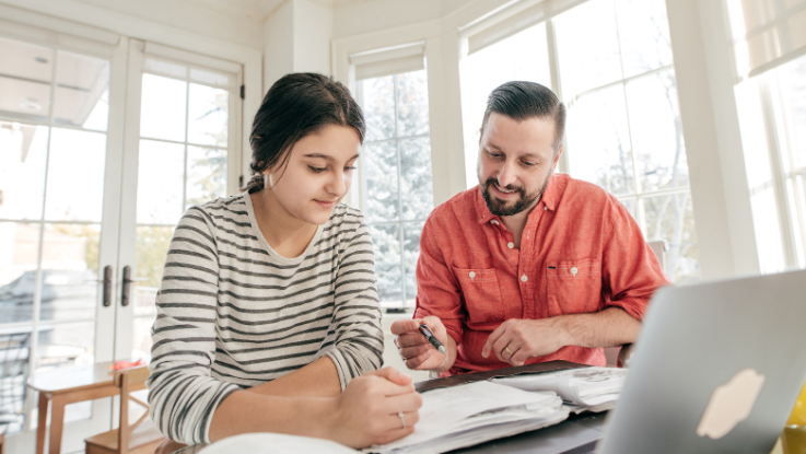 father helping their daughter with homework