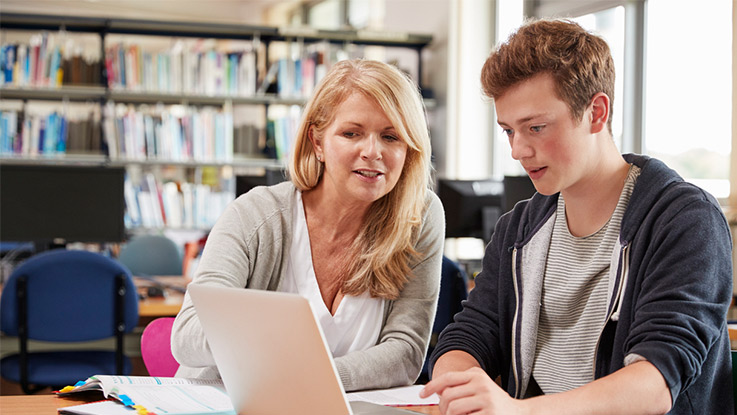 a vocational coach training a student in a library