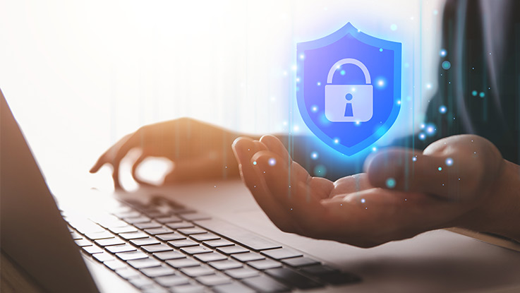 a person using a laptop with a hovering image of a padlock above their hand
