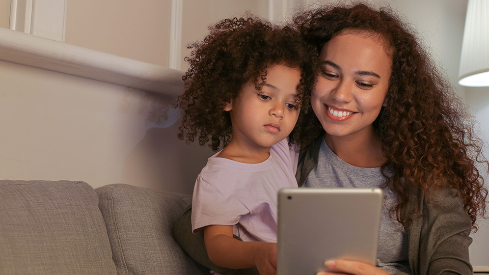 A mother and daughter using a tablet together