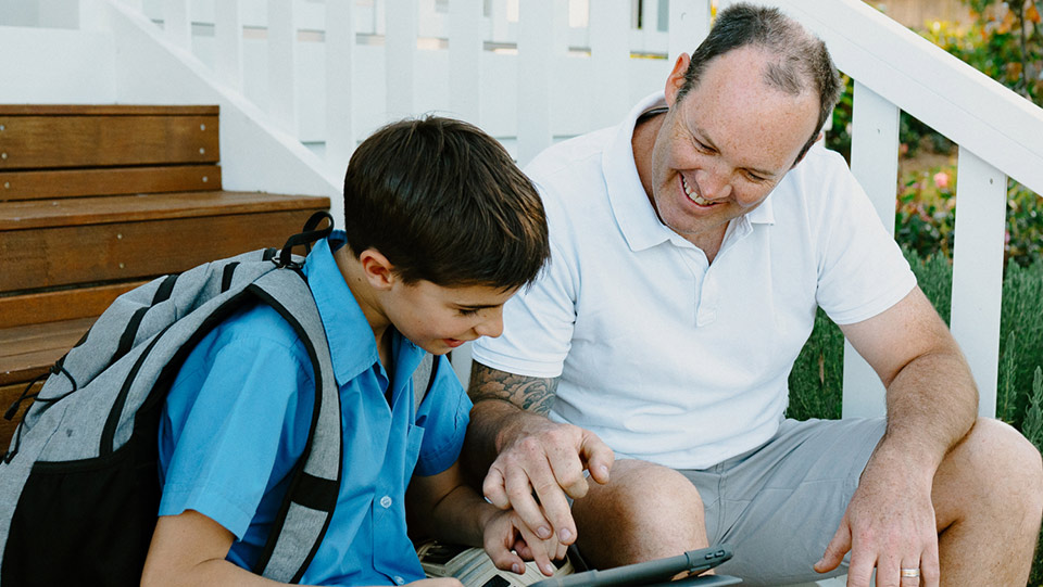 a father helping their young son with school work