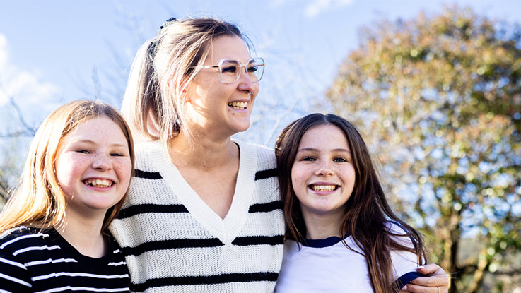 a mother posing with her two daughters