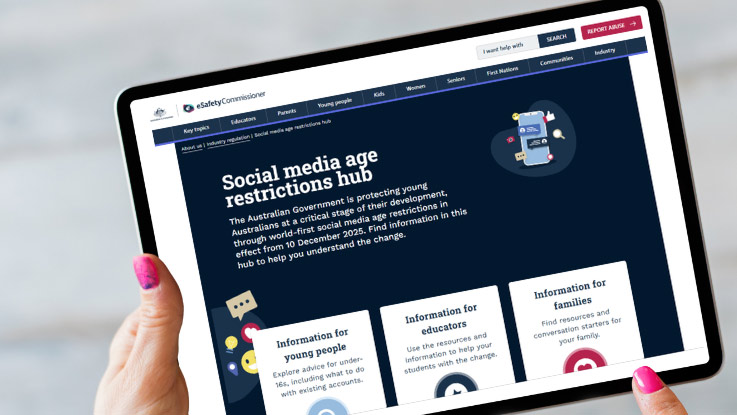 a person holding an ipad with the esafety website on it