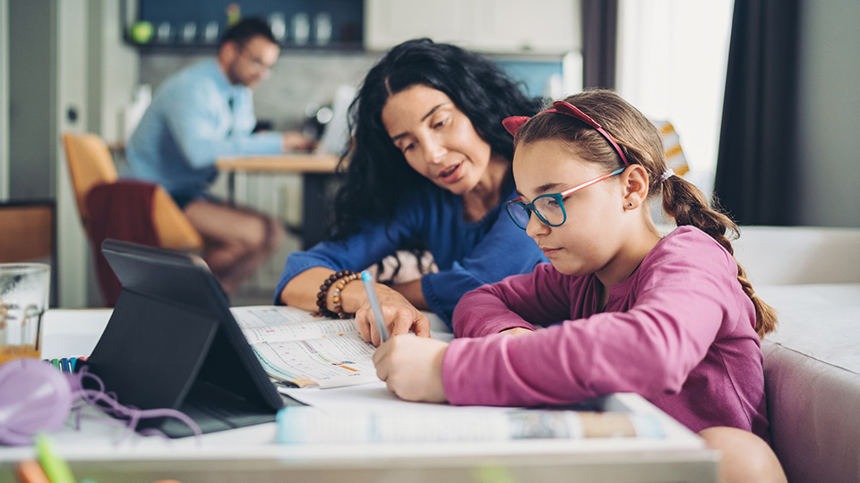 A mother helping her daughter do her homework.