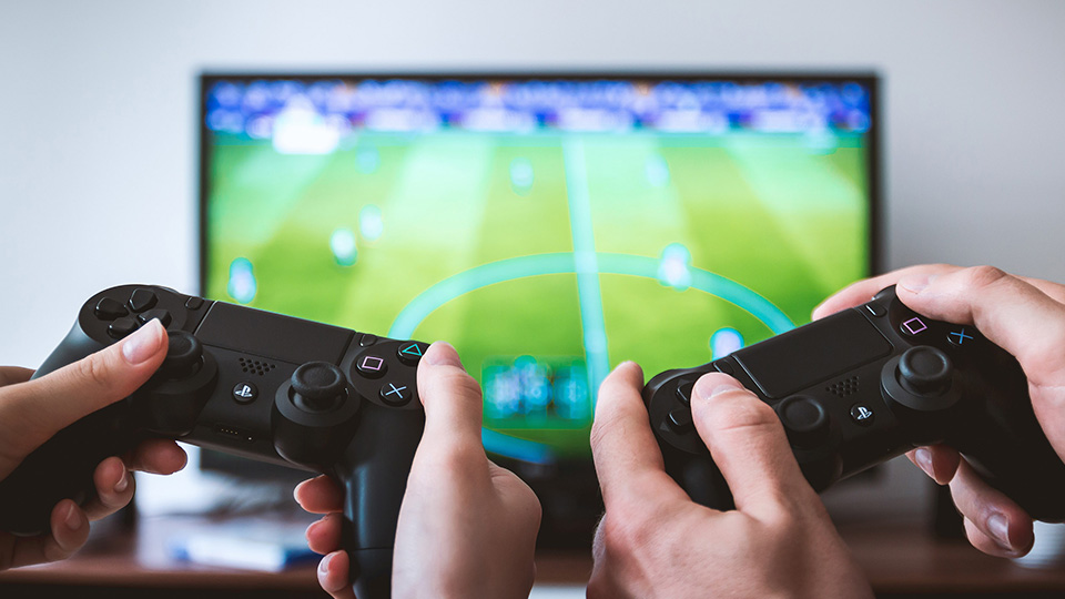 Two people play a playstation football game