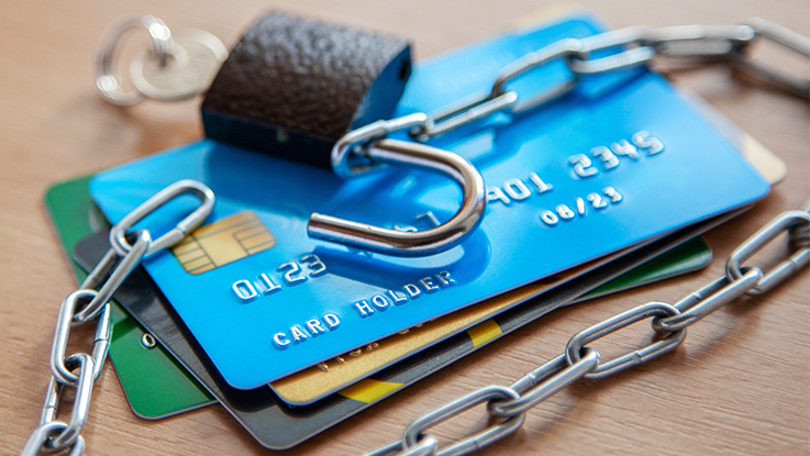 Close-up of stacked credit cards and a padlock, representing online payment security, fraud protection and secure transactions.
