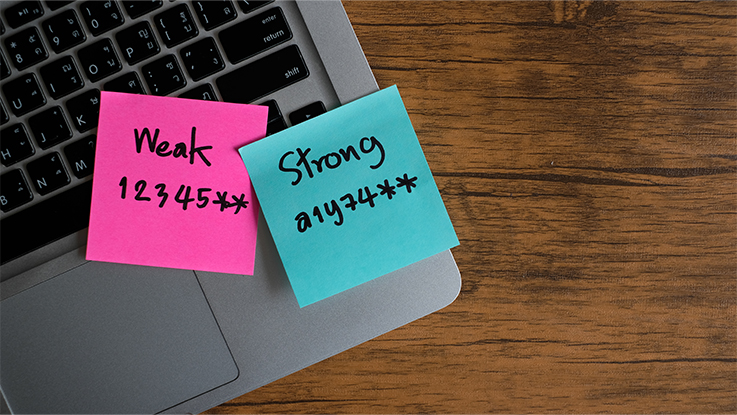 Sticky notes on a laptop keyboard displaying password reminders, representing weak password practices and online security risks.