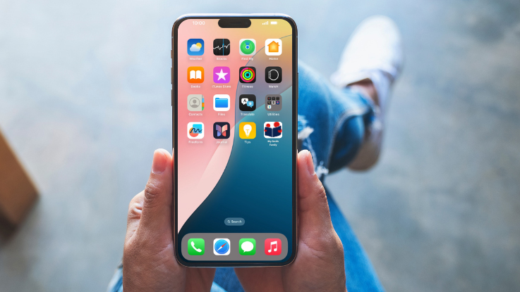 Close-up of a person holding a smartphone with app icons on the screen.
