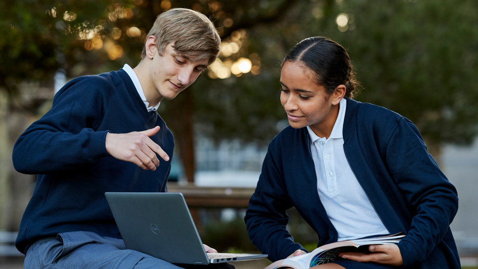 school students studying and looking at a laptop