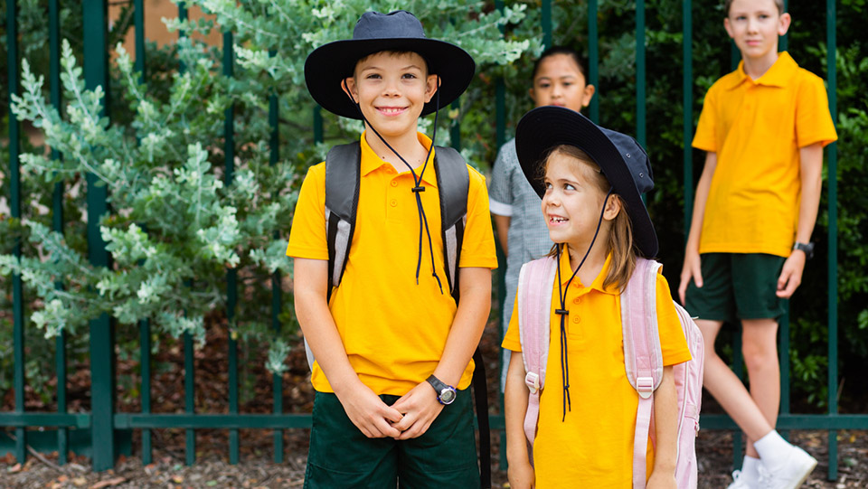 a group of school children standing in front of the school gate 
