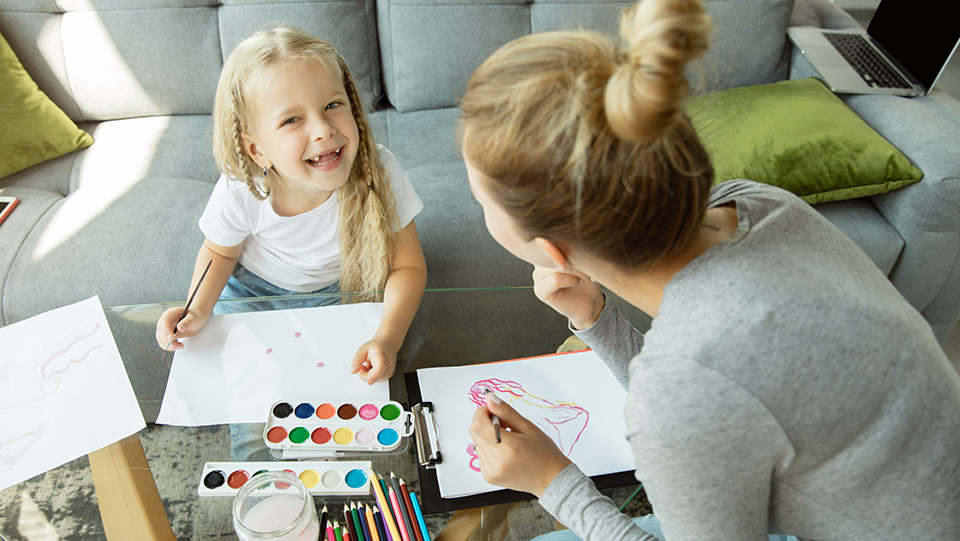 a young daughter playing with art and textas with her mum