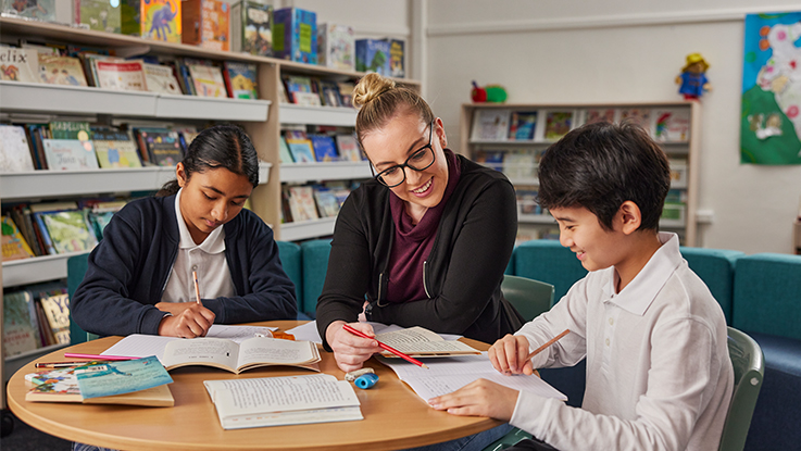 A teacher assisting two students
