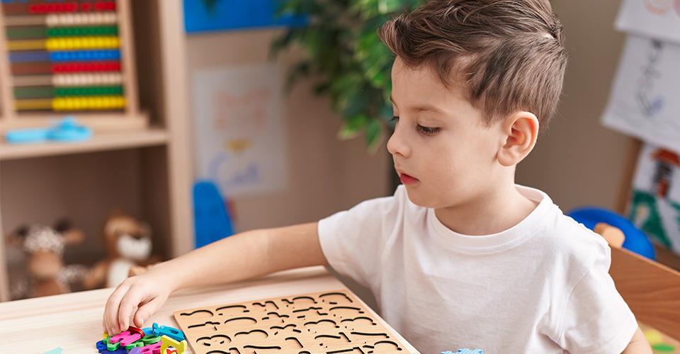 a young boy playing a letter puzzle