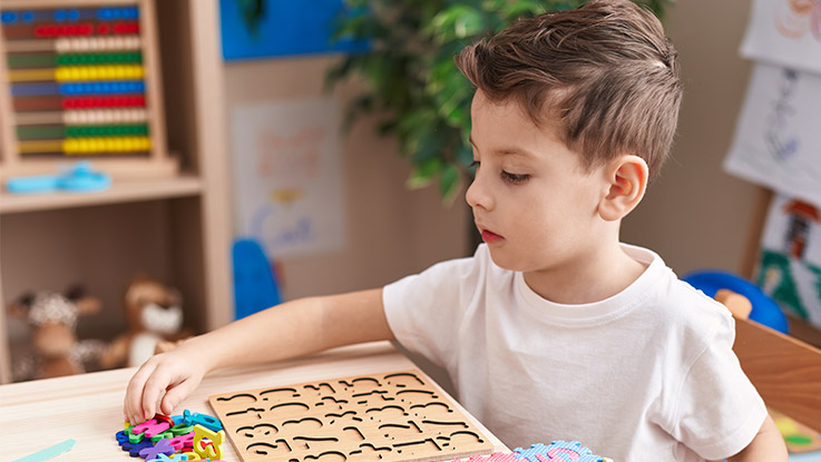 a young boy playing a letter puzzle