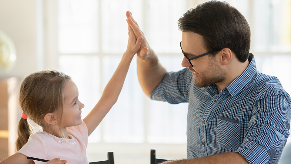 father and daughter cheerleader hi fiving