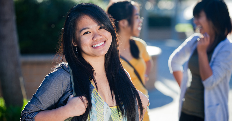 university student with backpack smiling outside