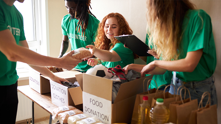 Community volunteers packing donated goods and groceries for distribution.