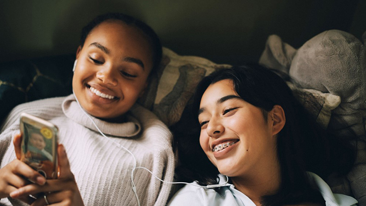 Two teenage girls looking at a mobile