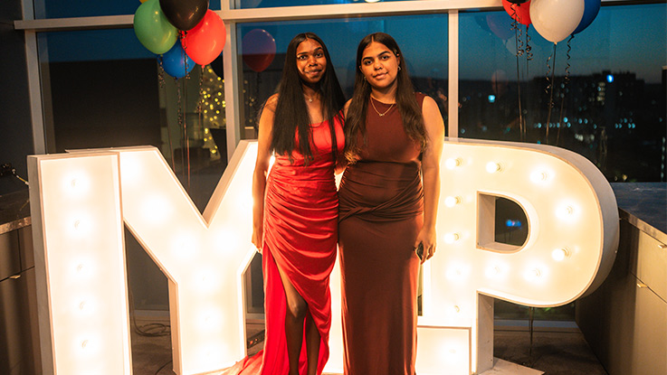 two girls standing side by side wearing formal maxi dresses