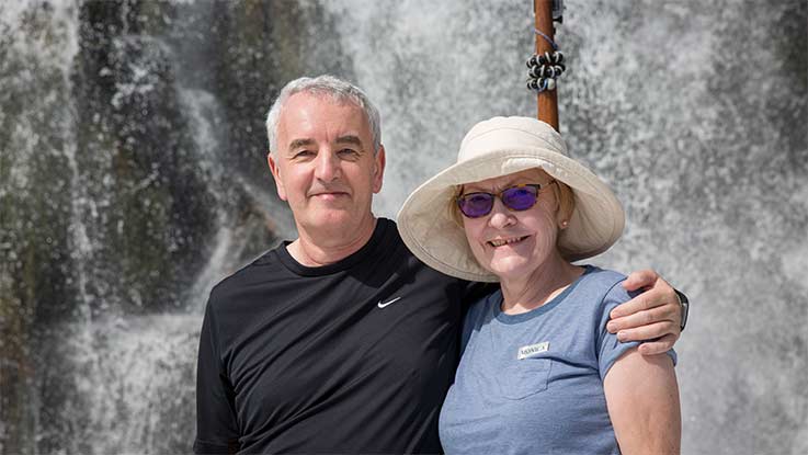 Couple standing in front of waterfall