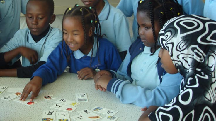 Group of kids learning through a card game in Bankstown
