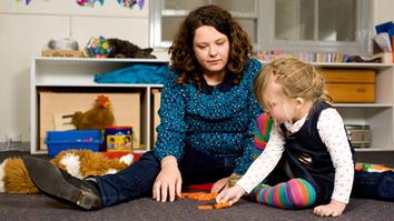 Mother and daughter learning to count through a game of dominoes